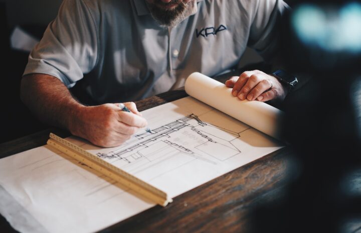 An architect working on a draft with a pencil and ruler