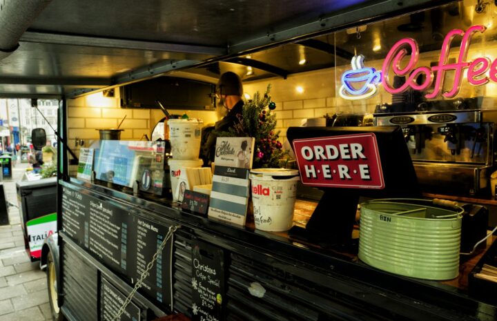 a coffee shop with a neon sign above the counter